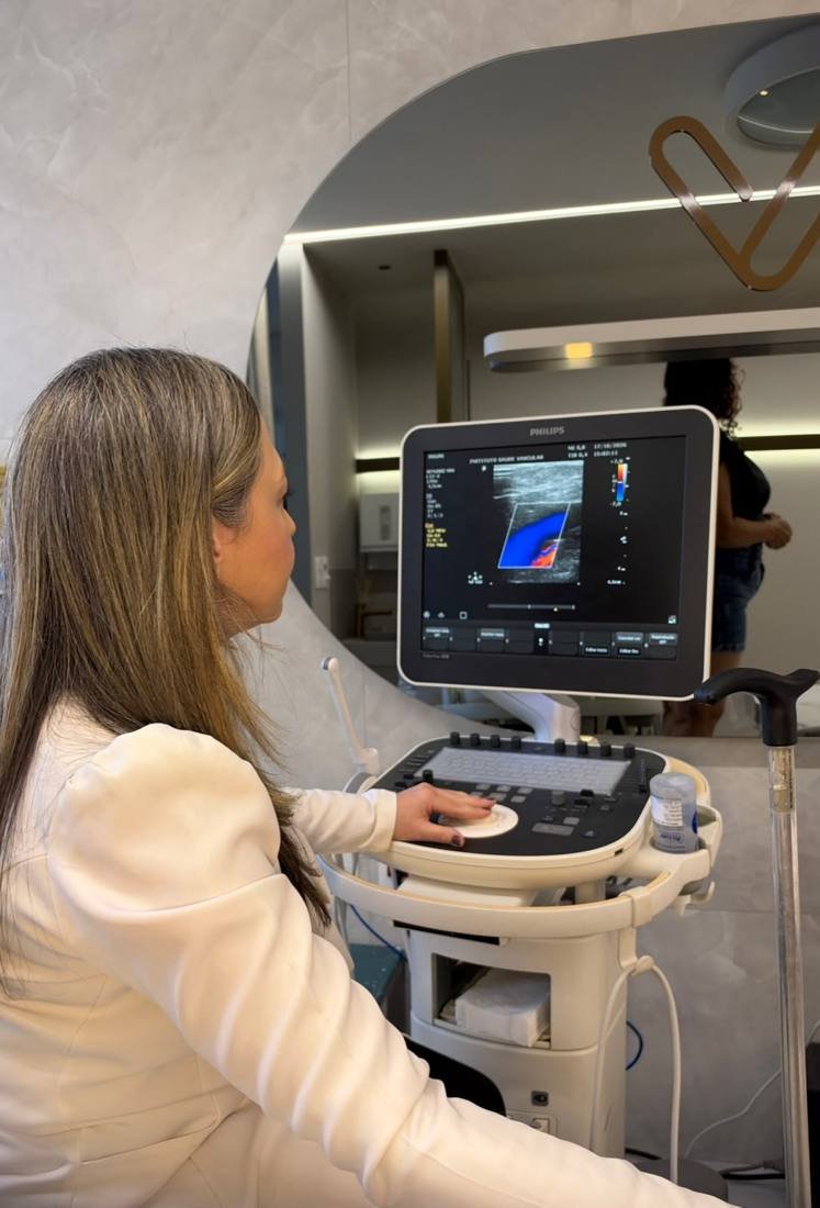 Dra. Aline realizando eco-Doppler colorido em aparelho de ultrassom