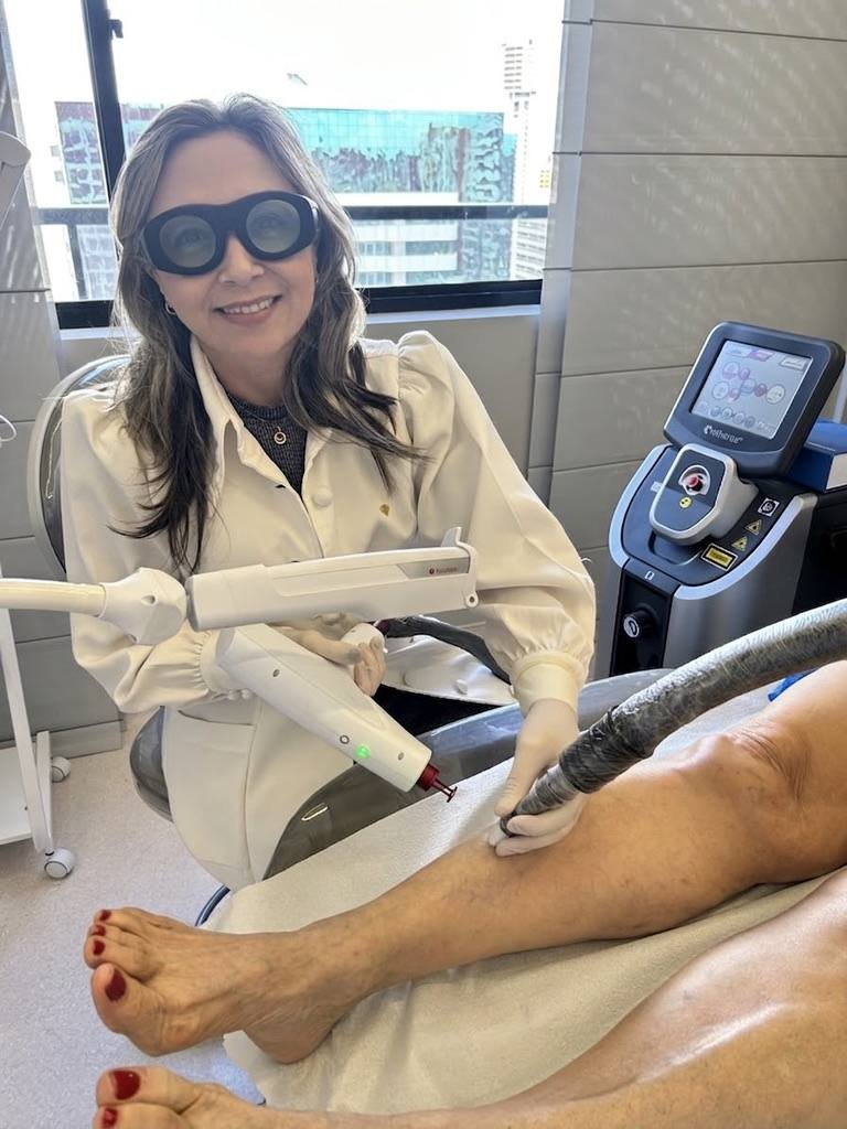 Aplicação de laser transdérmico na perna de uma paciente